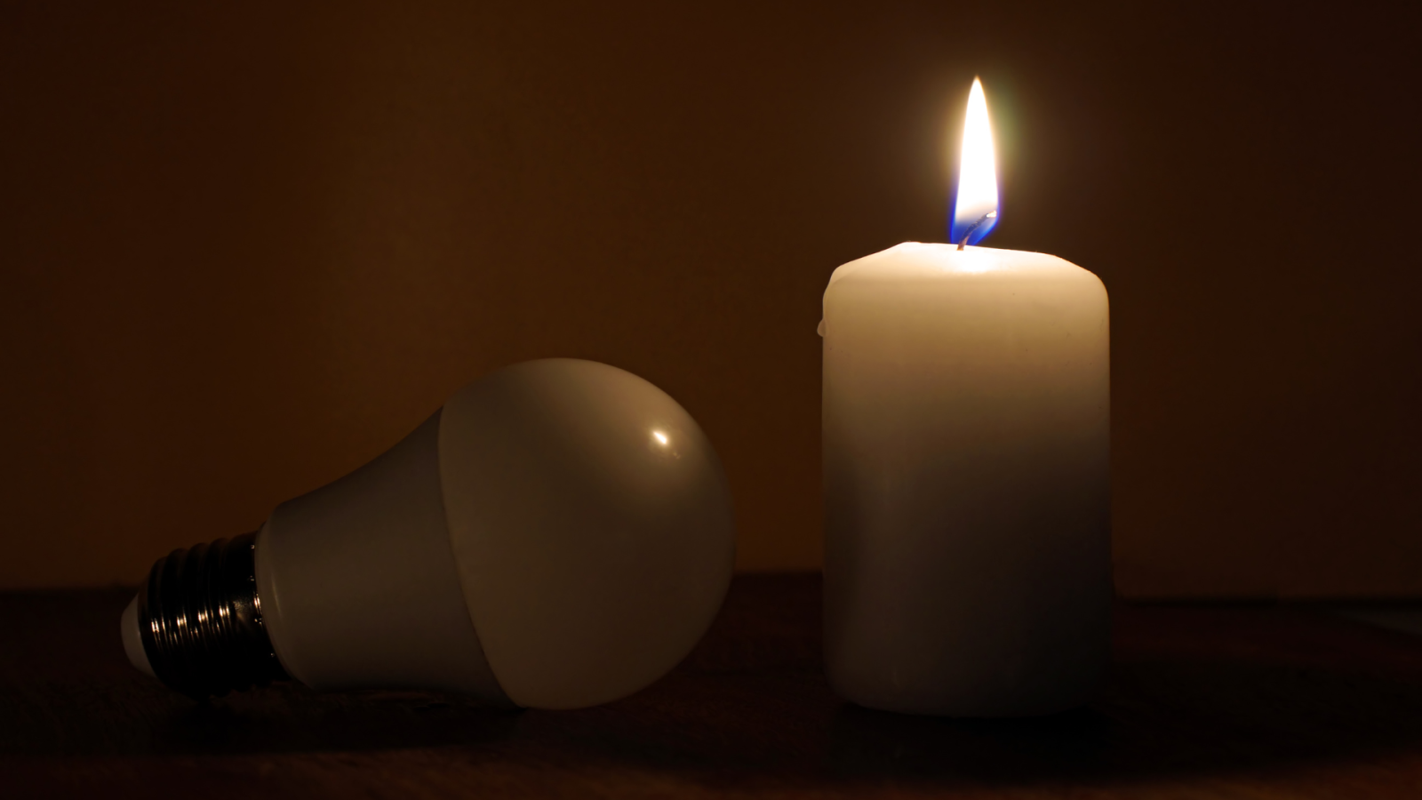 candela accesa e lampadina spenta
