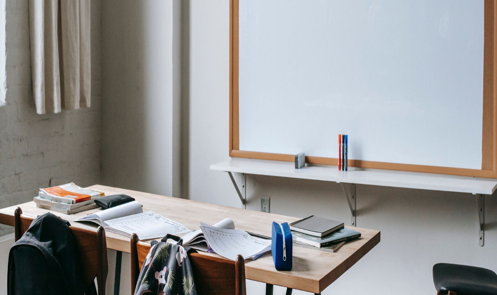 Interno di un'aula scolastica con banco e lavagna