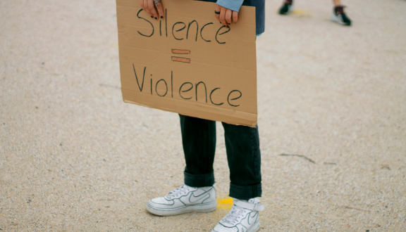 Ragazza che tiene un cartello con su scritto "Silence=Violence"