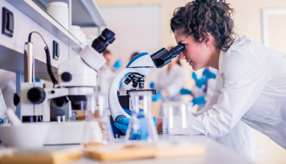 Una giovane ricercatrice al microscopio