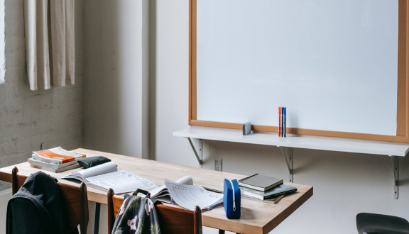 Interno di un'aula scolastica con banco e lavagna